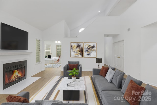 6523 Clavell Ln Unit I, Charlotte, NC 28210 - living area featuring a fireplace with flush hearth, wood finished floors, baseboards, and high vaulted ceiling