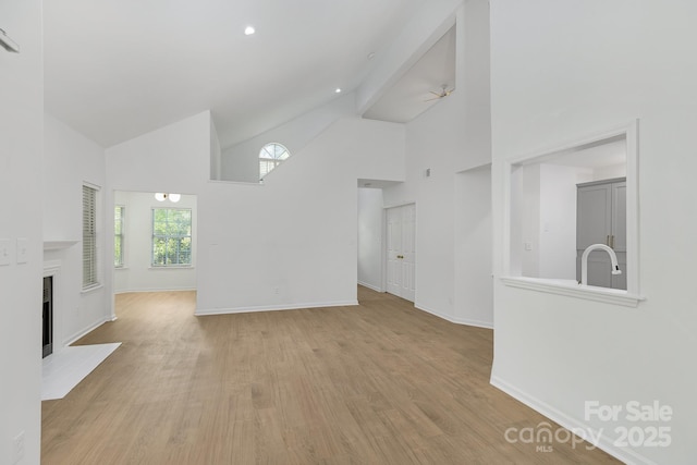 6523 Clavell Ln Unit I, Charlotte, NC 28210 - unfurnished living room featuring light wood-type flooring, a fireplace, baseboards, and high vaulted ceiling