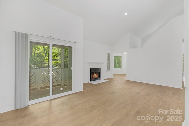 6523 Clavell Ln Unit I, Charlotte, NC 28210 - unfurnished living room featuring high vaulted ceiling, baseboards, a fireplace with flush hearth, and light wood finished floors