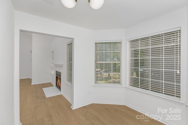 6523 Clavell Ln Unit I, Charlotte, NC 28210 - interior space featuring a fireplace with flush hearth, light wood-style floors, and baseboards