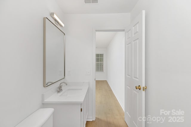 6523 Clavell Ln Unit I, Charlotte, NC 28210 - bathroom featuring wood finished floors, vanity, baseboards, toilet, and visible vents