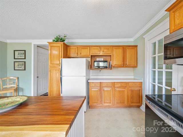 173 Odoms Chapel Rd, Bakersville, NC 28705 - kitchen featuring crown molding, electric stove, a textured ceiling, stainless steel microwave, and freestanding refrigerator