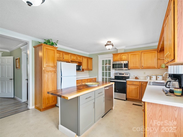 173 Odoms Chapel Rd, Bakersville, NC 28705 - kitchen with a center island, crown molding, a sink, light floors, and stainless steel appliances
