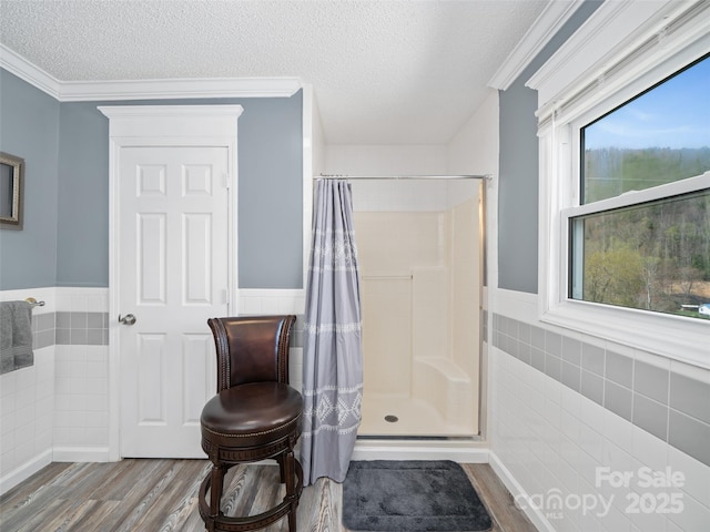 173 Odoms Chapel Rd, Bakersville, NC 28705 - full bathroom featuring a textured ceiling, tile walls, wainscoting, wood finished floors, and a shower with shower curtain