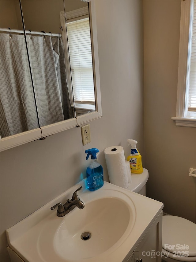 full bath with toilet, a shower with curtain, and vanity