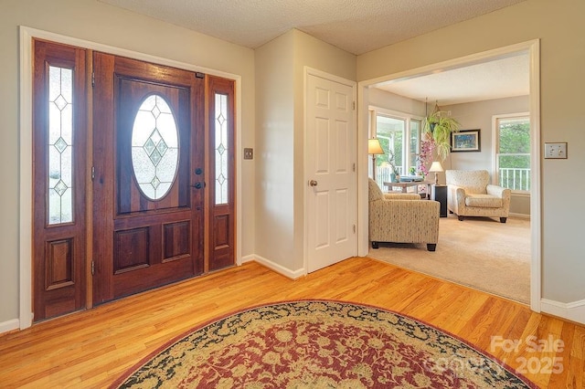 foyer entrance featuring baseboards and light wood finished floors