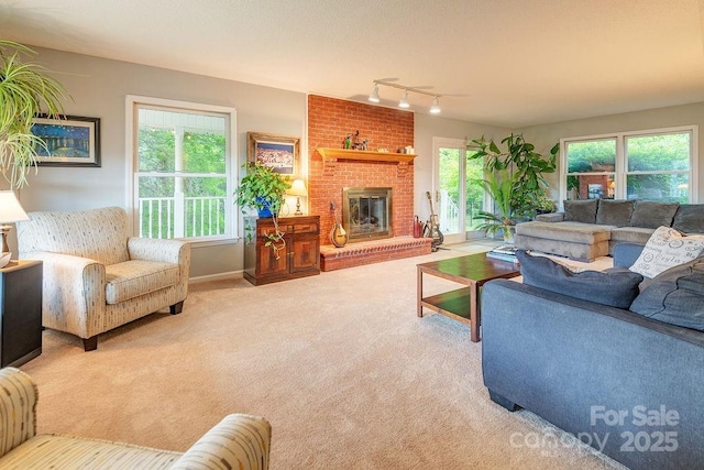 carpeted living area with rail lighting, baseboards, and a brick fireplace