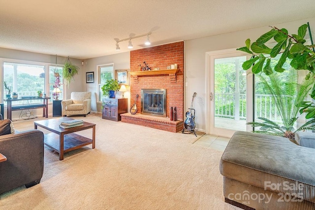 carpeted living room featuring a fireplace, plenty of natural light, track lighting, and tile patterned floors
