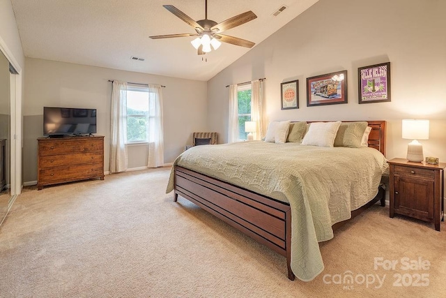 bedroom with lofted ceiling, light carpet, baseboards, and visible vents