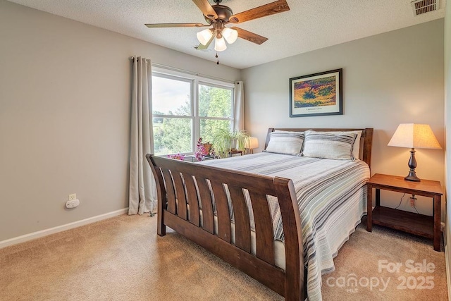 bedroom with light colored carpet, a textured ceiling, baseboards, and visible vents