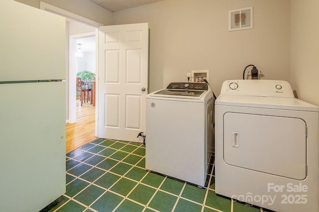 laundry area with tile patterned flooring, separate washer and dryer, laundry area, and visible vents