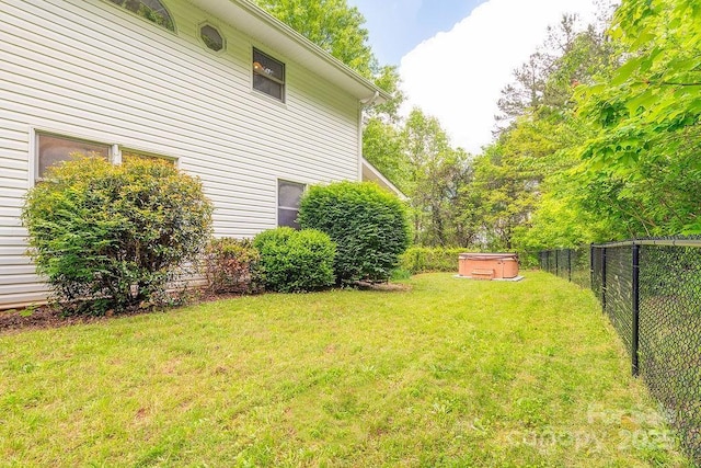 view of yard with a hot tub and a fenced backyard