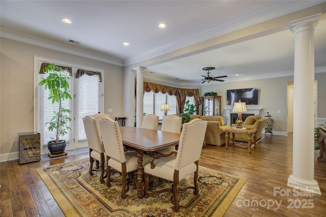 dining space with ornate columns, ceiling fan, visible vents, and hardwood / wood-style flooring