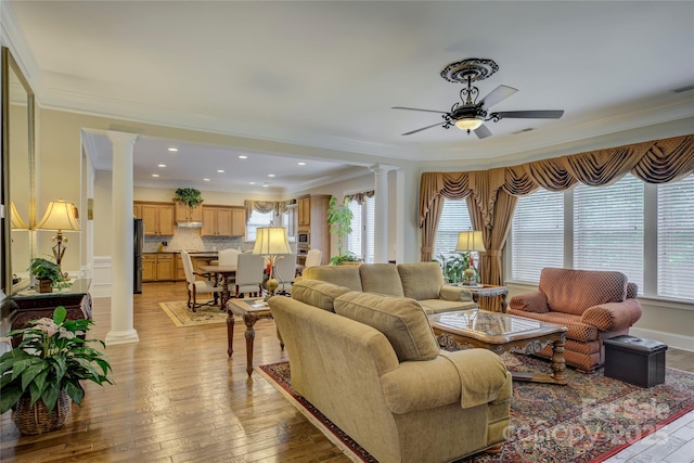 living room featuring ornamental molding, decorative columns, and a ceiling fan