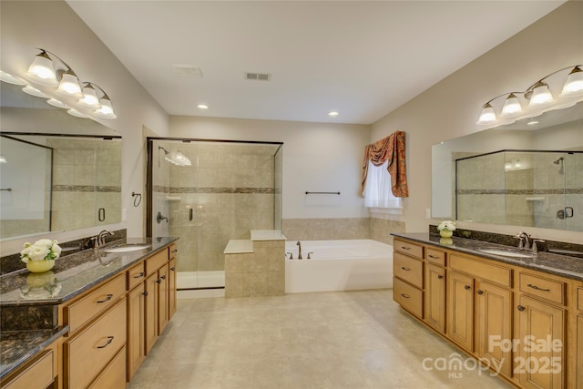 bathroom featuring visible vents, a sink, tile patterned floors, and a shower stall