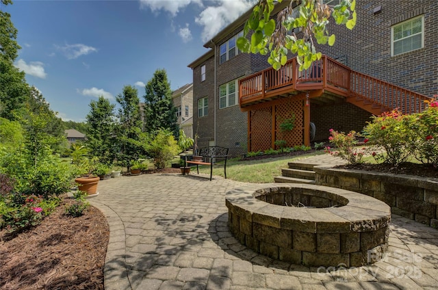view of patio / terrace with a deck, an outdoor fire pit, and stairway