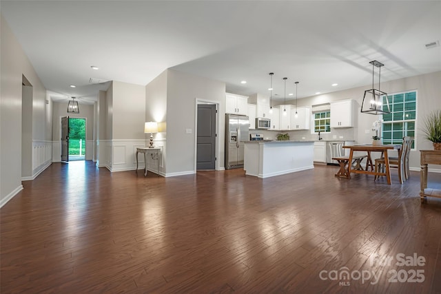 living room with visible vents, wainscoting, recessed lighting, and dark wood-type flooring