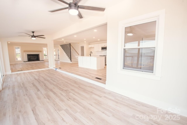 451 S Strand Dr, Norwood, NC 28128 - unfurnished living room with light wood-style flooring, a sink, baseboards, recessed lighting, and a ceiling fan