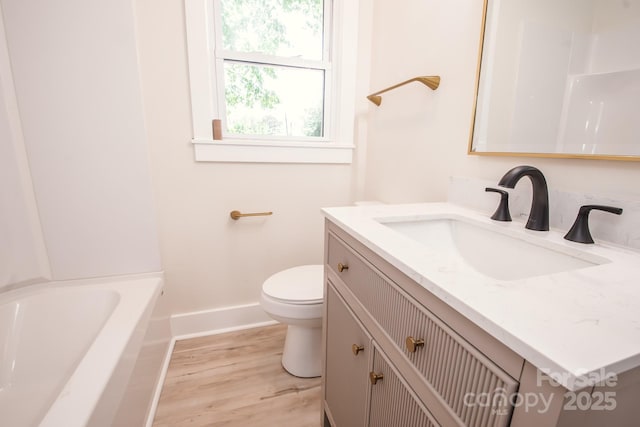 451 S Strand Dr, Norwood, NC 28128 - full bathroom with toilet, wood finished floors, a bathing tub, vanity, and baseboards