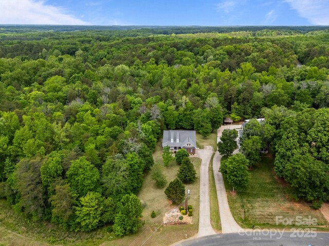 drone / aerial view with a wooded view