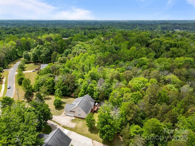 drone / aerial view with a wooded view