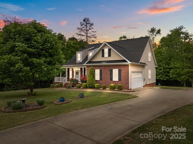 view of front of property featuring a front lawn, brick siding, a garage, a porch, and concrete driveway
