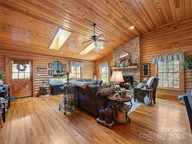 living area featuring ceiling fan, rustic walls, and a wealth of natural light
