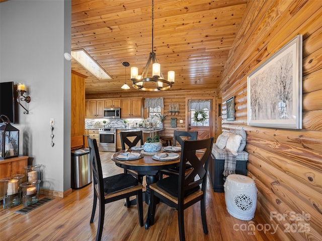 dining area featuring rustic walls, light wood finished floors, visible vents, wooden ceiling, and a notable chandelier