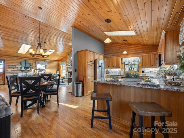 kitchen featuring plenty of natural light, wooden ceiling, stainless steel appliances, and a skylight