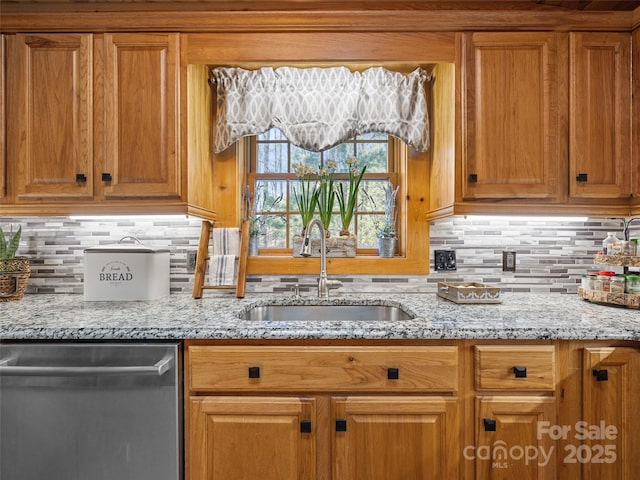 kitchen featuring light stone counters, tasteful backsplash, a sink, brown cabinets, and dishwasher