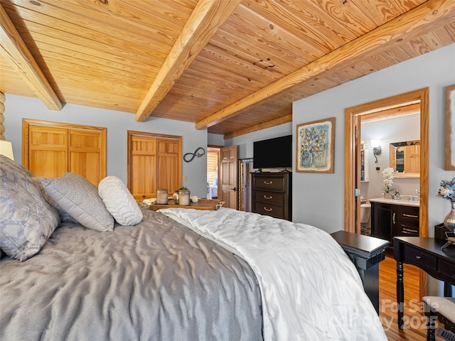 bedroom featuring wood finished floors, wooden ceiling, beamed ceiling, two closets, and ensuite bathroom