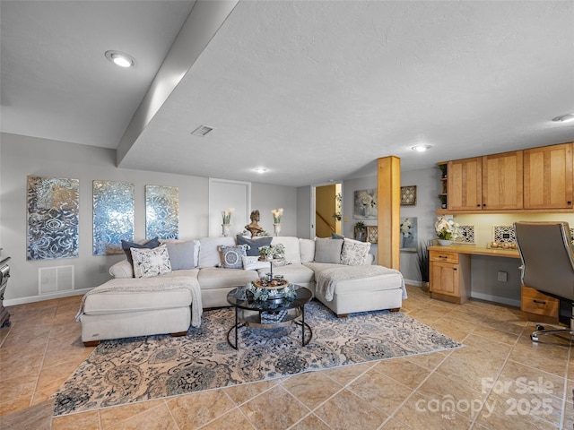 living room with recessed lighting, a textured ceiling, visible vents, and baseboards