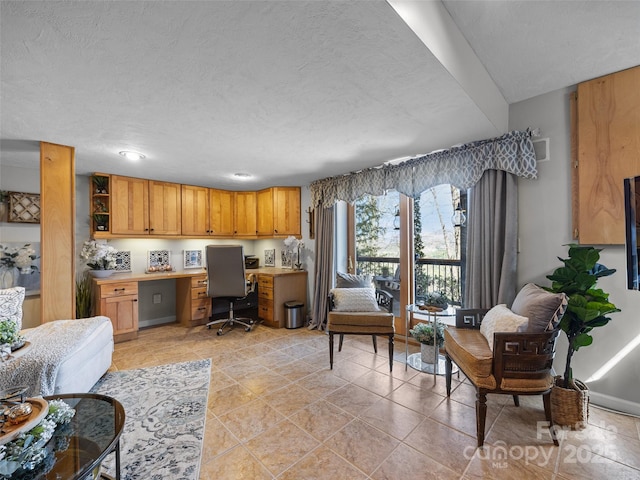 living area featuring built in desk and a textured ceiling
