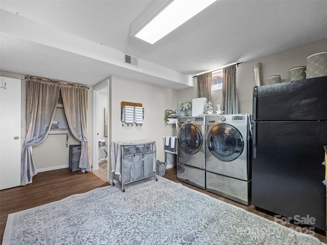 laundry room with laundry area, wood finished floors, visible vents, baseboards, and separate washer and dryer