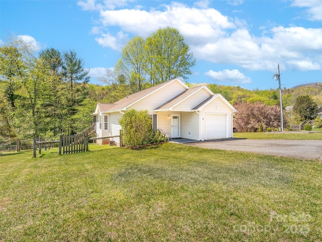 single story home with fence, aphalt driveway, a front yard, and a garage