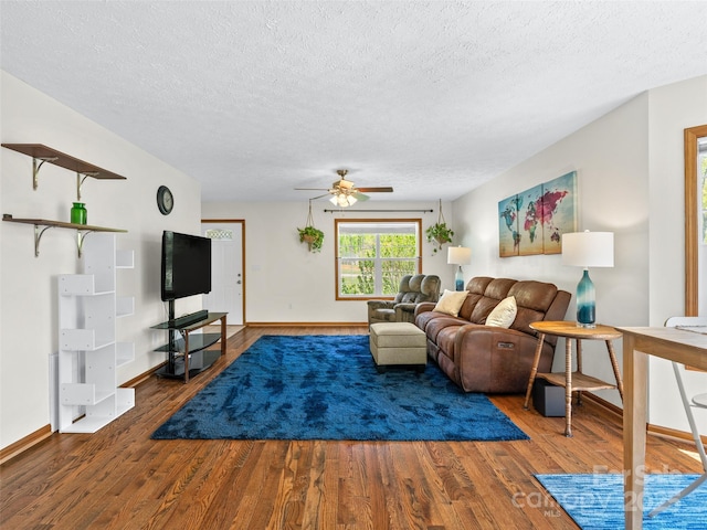 living area featuring wood finished floors, a textured ceiling, and a ceiling fan
