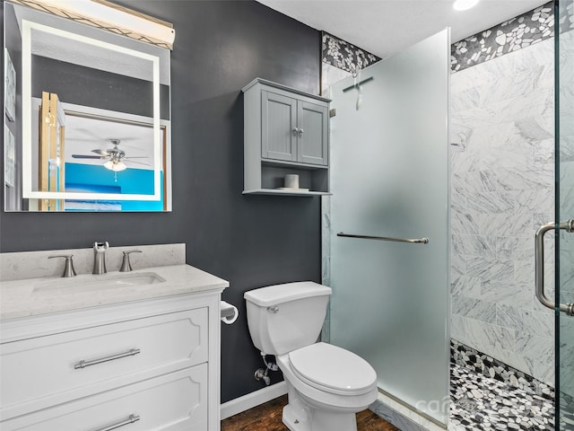 full bathroom with toilet, baseboards, a shower stall, ceiling fan, and vanity