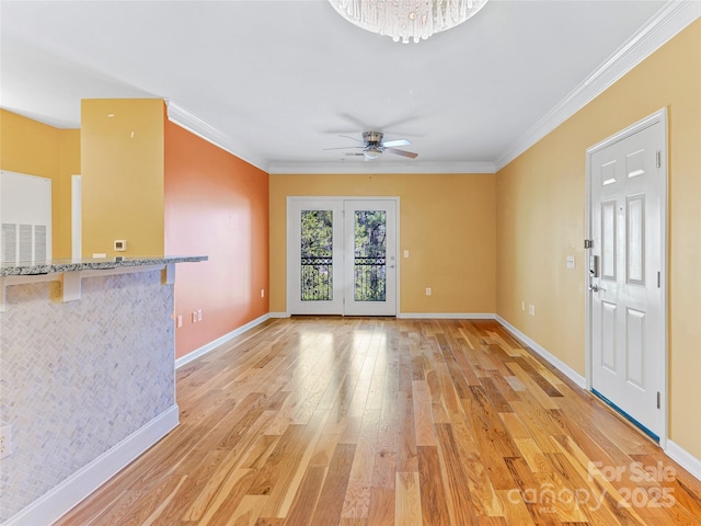 unfurnished living room featuring light wood-style flooring, baseboards, visible vents, a ceiling fan, and ornamental molding