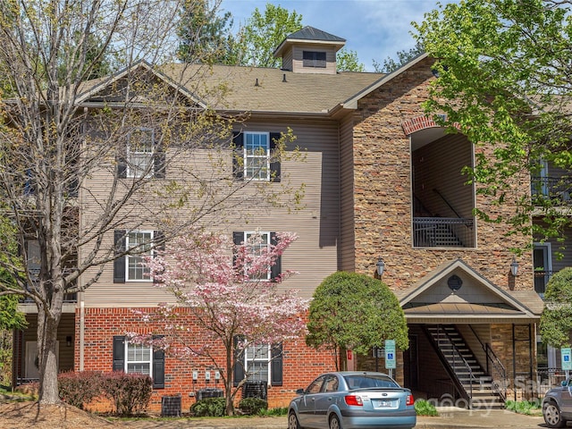 view of front facade featuring brick siding and stairs