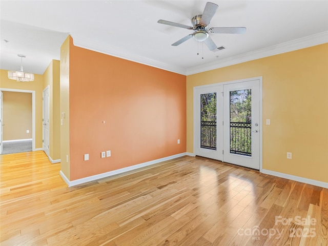 empty room featuring baseboards, ornamental molding, visible vents, and light wood-type flooring