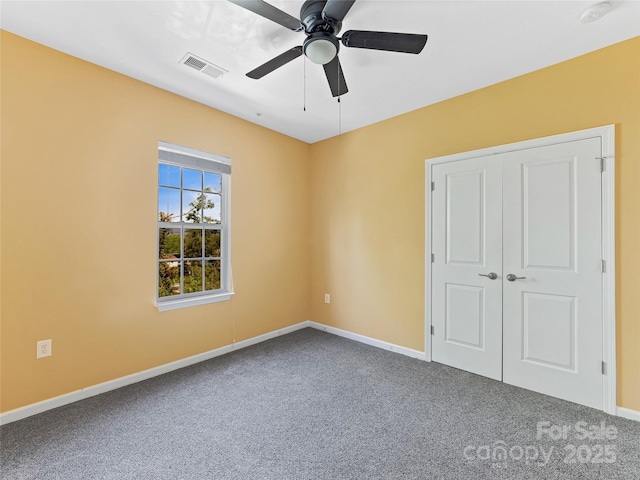 unfurnished bedroom featuring baseboards, a ceiling fan, visible vents, and carpet
