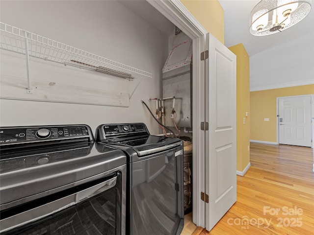 washroom featuring light wood-type flooring, baseboards, ornamental molding, laundry area, and independent washer and dryer