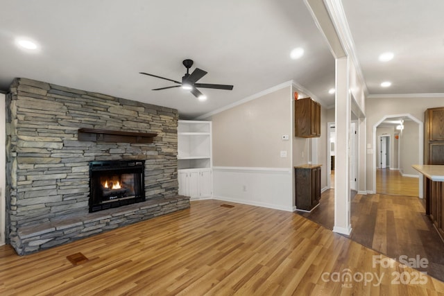 2942 Denwood Dr, Claremont, NC 28610 - unfurnished living room featuring wood finished floors, ornamental molding, arched walkways, a fireplace, and ceiling fan