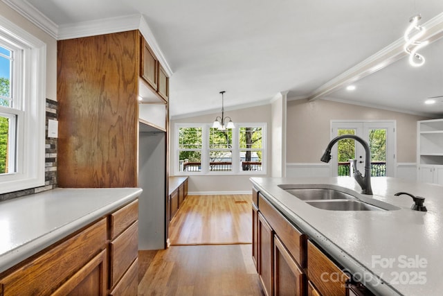 2942 Denwood Dr, Claremont, NC 28610 - kitchen featuring vaulted ceiling, a sink, brown cabinets, a chandelier, and light wood finished floors