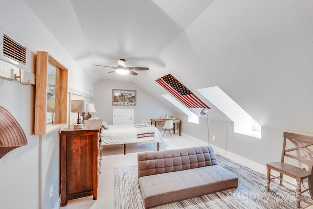 carpeted living area with lofted ceiling with skylight, a ceiling fan, visible vents, and baseboards