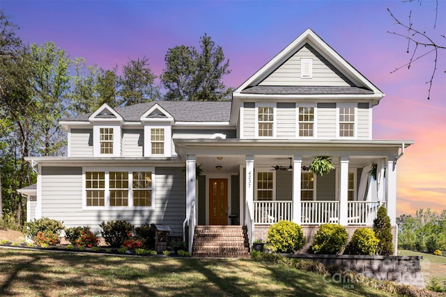 traditional home featuring a front yard and covered porch