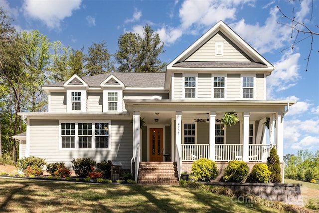 traditional-style home featuring a porch, a front lawn, and a shingled roof