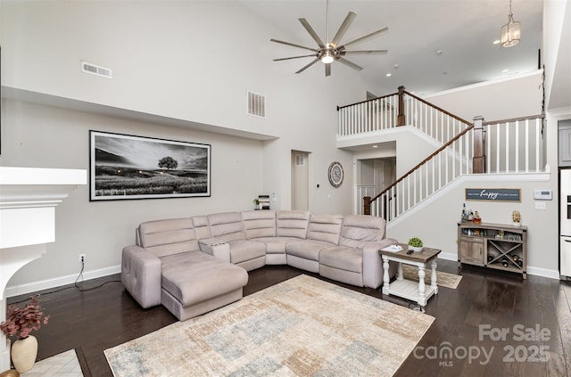 living room featuring stairway, visible vents, dark wood-style flooring, and ceiling fan
