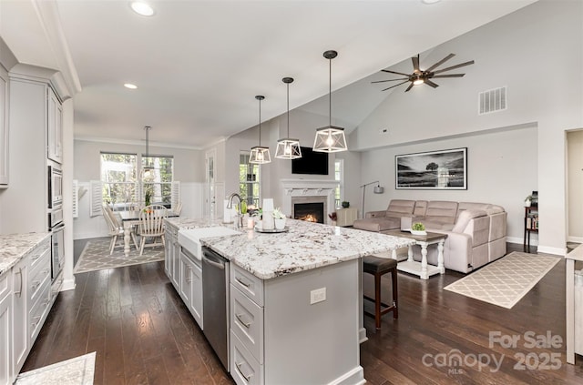 kitchen featuring a high end fireplace, open floor plan, stainless steel appliances, visible vents, and recessed lighting