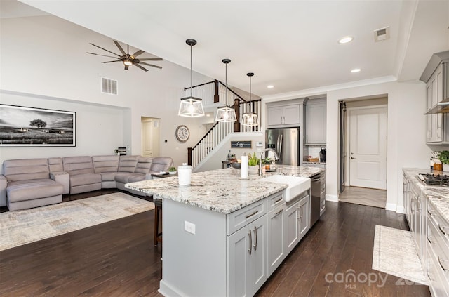 kitchen featuring visible vents, appliances with stainless steel finishes, open floor plan, and gray cabinetry